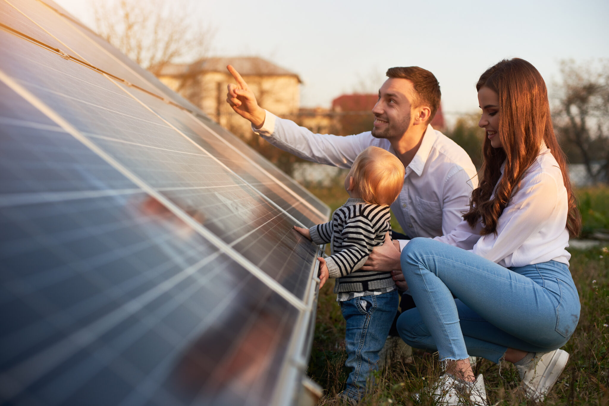Famille heureuse devant des panneaux photovoltaïques grâce à la garantie à vie IsoForLife