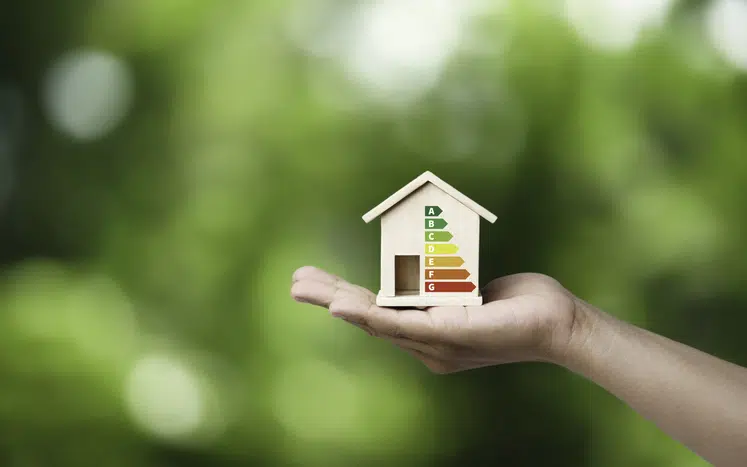 House energy efficiency, energy efficient rating class concept, eco home renovation save cost. Low-consumption ecological house. Hand holding Green Building for Sustainable Development Concept